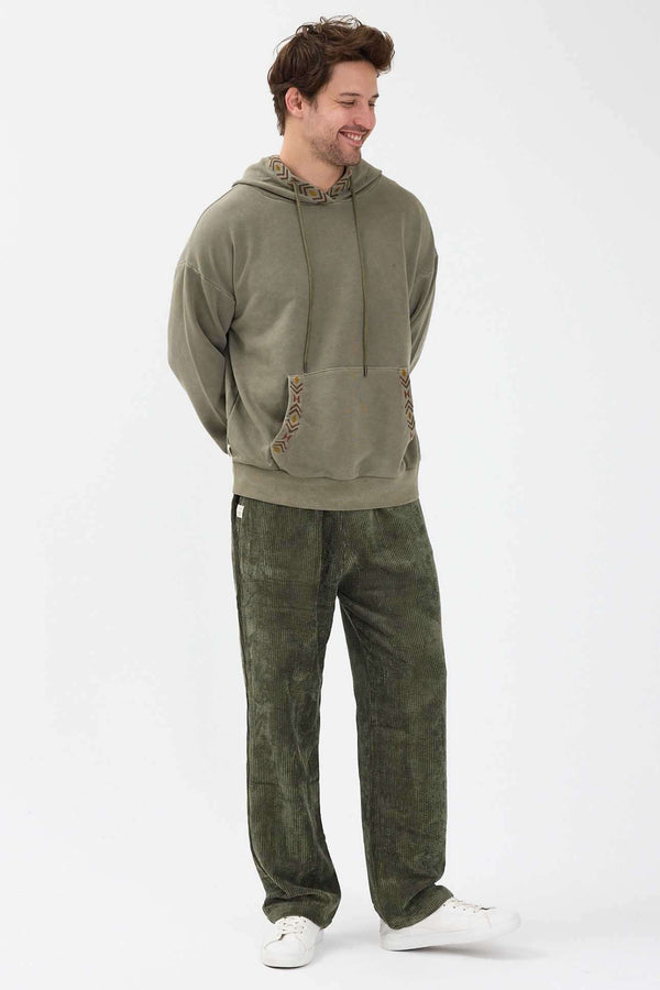 Sage Kapşonlu Nakışlı Sweatshirt giyen erkek manken, rahat kış kombininde.