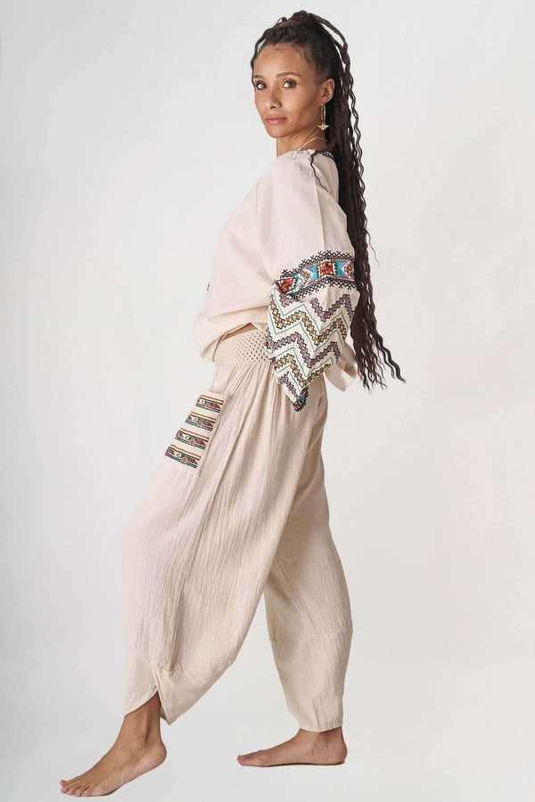 Kadın Sand Baggy Etnik Pantolon ile kombinlenmiş pamuklu üst, rahat ve şık bir görünüm sunuyor.