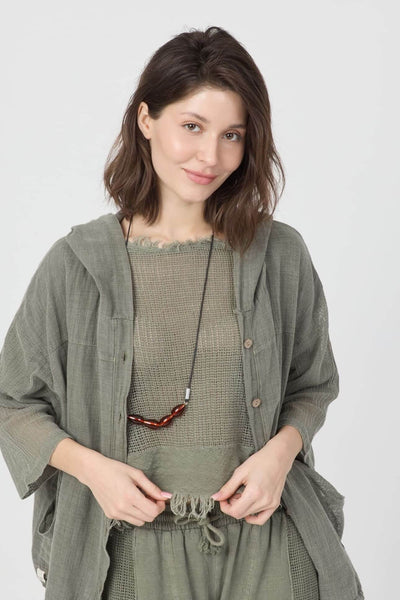 Forest Pamuk Bluz model wearing soft green organic cotton outfit with lace trim and a stylish necklace.